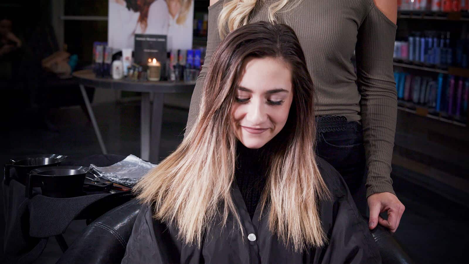 A before image of a girl with grown out hair getting ready for the babylights balayage technique.