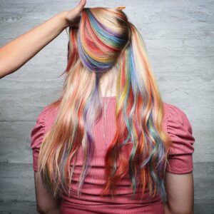 Woman with rainbow highlights weaved throughout blonde hair
