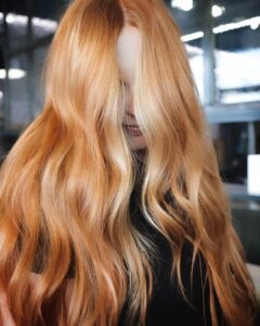 Woman with long coppery orange fantasy color hair