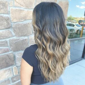 Woman with dark roots and a blonde balayage