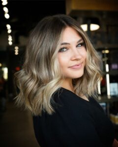 woman with a short blonde balayage and money piece