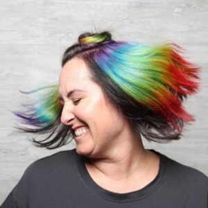Woman with short dark hair with rainbow fantasy color throughout